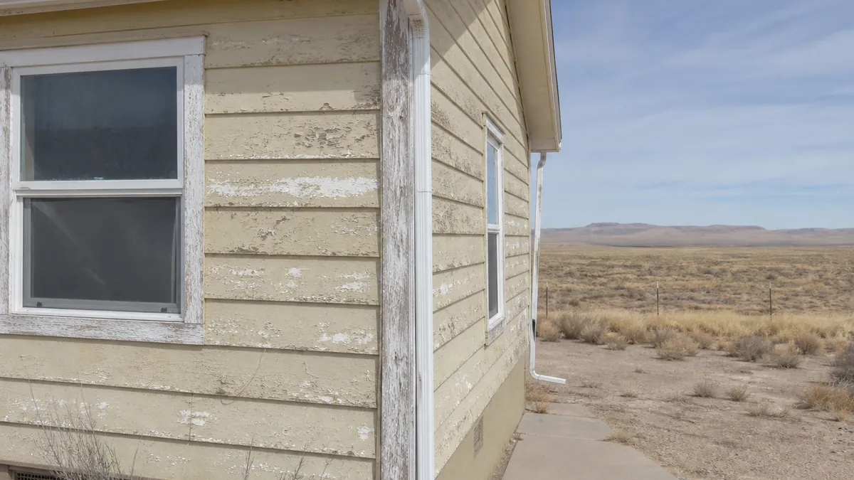 Wind-worn exterior siding before a repaint in Wamsutter, Wyoming.